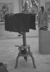 Roma. Palazzo delle Esposizioni. IV Quadriennale. Allestimento mostra - banco ottico al centro della sala; sullo sfondo una scultura "vestita" con una giacca