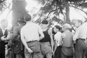 Gruppo di persone riunito in discussione sotto gli alberi
