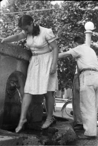 Milano. Parco Sempione. Una ragazza si rinfresca bagnandosi le gambe alla "Fontana dell'acqua marcia"