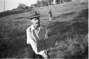 Invasione delle terre. Un contadino pianta un cartello con scritto "terra ai contadini"