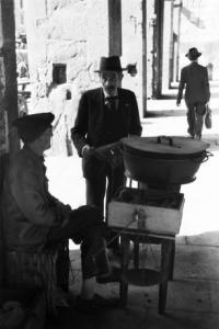 Italia Dopoguerra. Genova - Un uomo avvicina un ambulante sotto i portici di un edificio