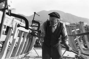 Italia Dopoguerra. Camogli - Porto - anziano carpentiere al lavoro nella costruzione di una barca