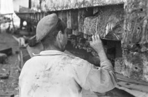 Italia Dopoguerra. Camogli - Porto - operaio che osserva la struttura del piccolo cantiere