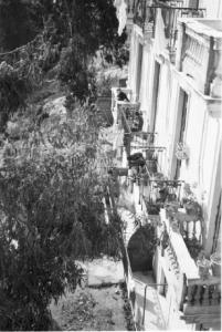 Italia Dopoguerra. Napoli. Abitazione. Una donna cuce seduta sul balcone