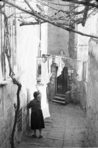 Italia Dopoguerra. Napoli. Una donna stende i panni all'esterno della propria abitazione