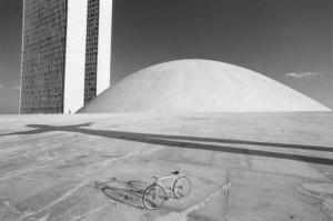 Brasilia. Bicicletta da corsa davanti a una delle due cupole del Congresso Nazionale, con i due grattacieli sullo sfondo