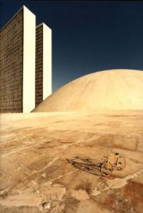 Brasilia. Bicicletta da corsa davanti a una delle due cupole del Congresso Nazionale, con la base del doppio grattacielo sullo sfondo
