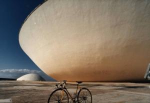 Brasilia. Bicicletta da corsa davanti a una delle due cupole del Congresso Nazionale, con l'altra sullo sfondo