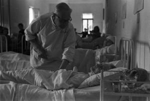 Diano Marina. Ospedale. Malati di tifo. Un dottore visita una paziente - sullo sfondo la camerata con infermiere e pazienti