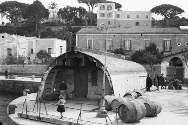 Italia Dopoguerra. Forio. Banchina di attracco dei traghetti. Una bambina cammina su una passerella