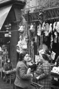 Italia Dopoguerra. Napoli. Donne davanti al negozio di carni di maiale "Al suino d'oro"
