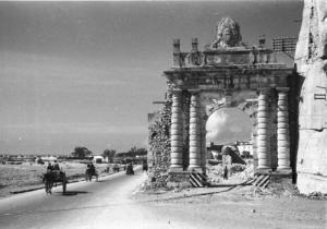 Italia Dopoguerra. Terracina. Edifici distrutti dai bombardamenti. Carretti e automezzi percorrono una via