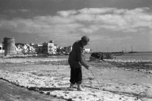 Italia Dopoguerra. Mondello. Un pescatore sistema le reti sulla spiaggia