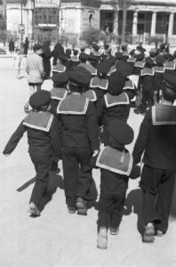 Italia Dopoguerra. Palermo. Gruppo di studenti in divisa scolastica da marineretto cammina lungo la strada accompagnato da due suore