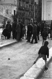 Italia Dopoguerra. Palermo. Un gruppo di uomini in piazza. Bambini giocano intorno