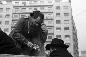 Italia Dopoguerra. Milano. Un uomo in divisa su un camion conta i soldi