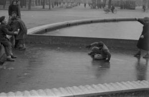 Italia Dopoguerra. Milano. Ragazzini giocano nella fontana gelata di fronte al Castello Sforzesco