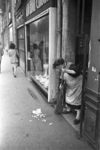 Parigi. Una donna spazza l'uscio di un portone