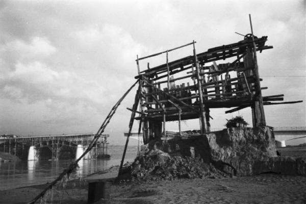 Italia Dopoguerra. Roma. Ponte sul Tevere in costruzione. L'ossatura in legno di un edificio e ponte in costruzione sullo sfondo