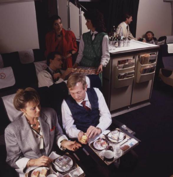 Alitalia. Interno della economy class di un aeromobile - gruppo di passeggeri durante il pranzo