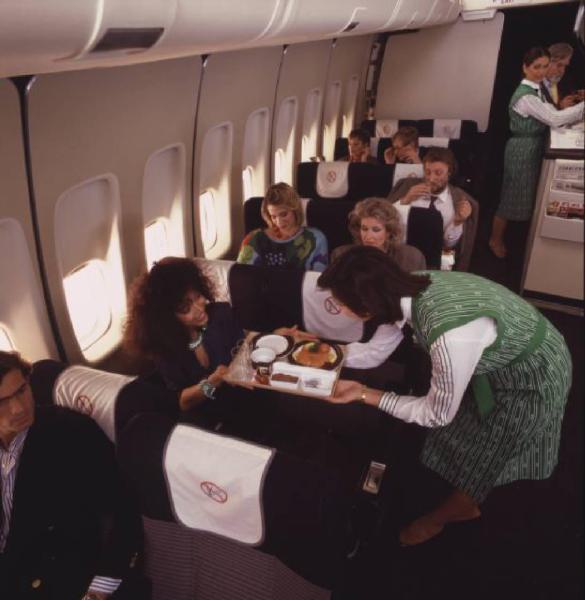 Alitalia. Interno della economy class di un aeromobile - gruppo di passeggeri durante il pranzo