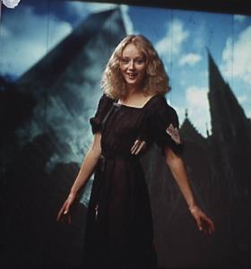 Fotomodella in abito scuro posa davanti a un fondale che riproduce una immagine della città di New York