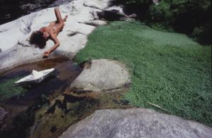 Val Verzasca - fotomodella nuda sdraiata su una pietra a margine di un corso d'acqua