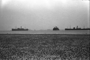 Normandia. Le spiaggie teatro dello sbarco alleato con la bassa marea. Sullo sfondo navi da guerra