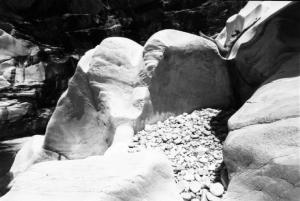 Val Verzasca - fotomodella nuda sdraiata all'interno di un massiccio roccioso