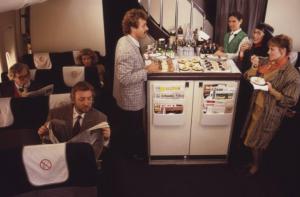 Alitalia. Interno della business class di un aeromobile - gruppo di passeggeri attorno al carrello pranzo