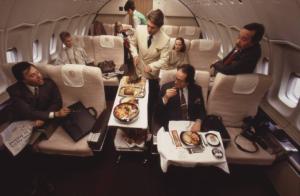 Alitalia. Interno della business class di un aeromobile - passeggeri e stewart durante il servizio pranzo
