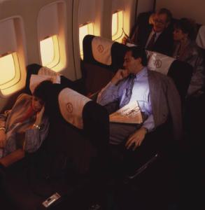 Alitalia. Interno della economy class di un aeromobile - gruppo di passeggeri in riposo