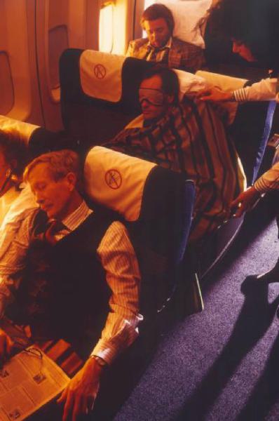 Alitalia. Interno della economy class di un aeromobile - passeggeri che dormono accuditi da una hostess