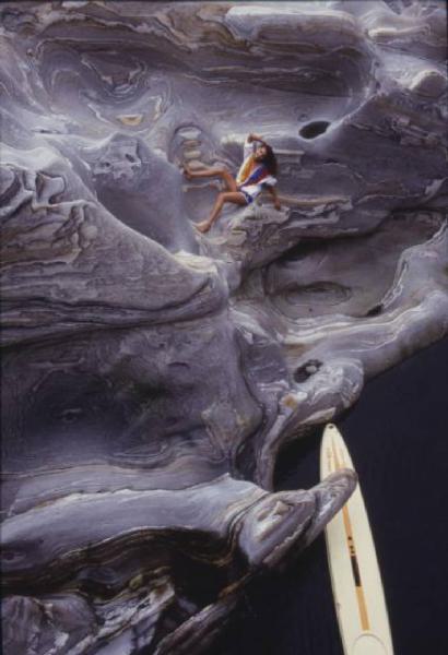 Valle Verzasca. Modella sdraiata sulla roccia. Sullo sfondo un windsurf