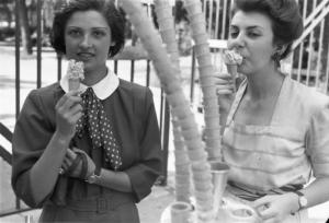 Milano. Parco Sempione. Due giovani donne mangiano il gelato in cono - in primo piano coni impilati