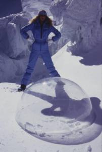 Campagna pubblicitaria Ellesse. Fotomodella indossa completo da sci azzurro - neve - sfera di plexiglass