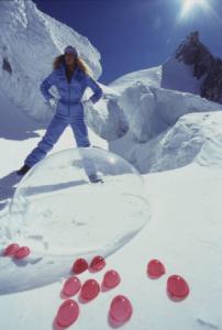 Campagna pubblicitaria Ellesse. Fotomodella indossa completo da sci azzurro - neve - sfera di plexiglass - bolle rosse