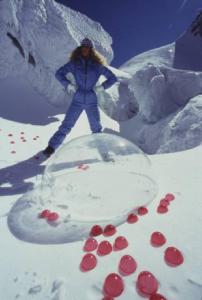 Campagna pubblicitaria Ellesse. Fotomodella indossa completo da sci azzurro - neve - sfera di plexiglass - bolle rosse