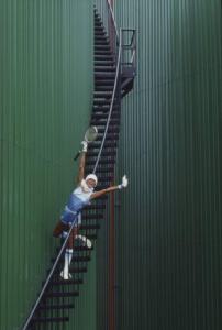 Modella con racchetta da tennis sulla scalinata di un gasometro