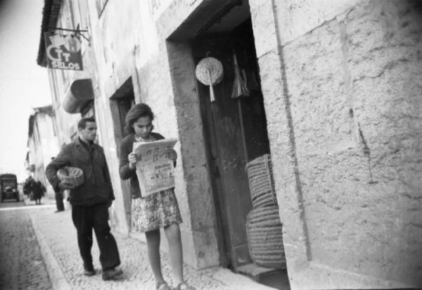 Lisbona. Ragazzina legge il giornale per strada