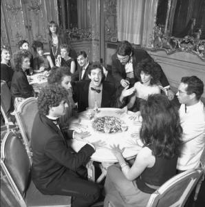 Campagna pubblicitaria Perugina. Scena di una festa - persone sedute a un tavolo congiungono le mani per una seduta spiritica - cioccolatini