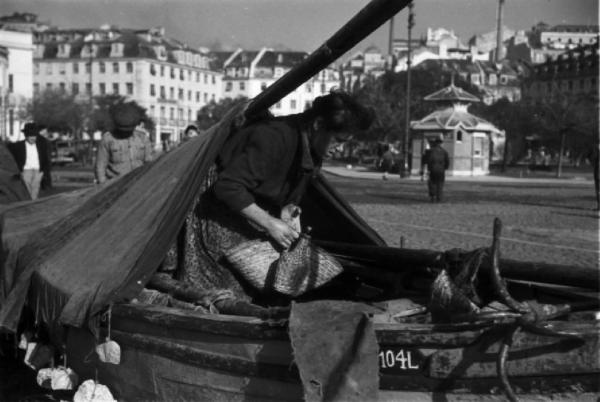 Lisbona. Il porto - imbarcazione tirata in secca e donna lusitana con fiasco in mano