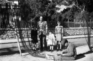 Estoril. Famiglia Savoia in esilio. Umberto II e i principini osservano un pescatore che aggiusta le reti