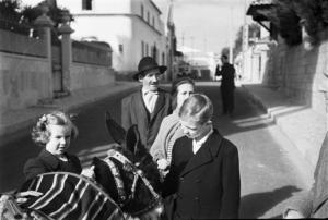 Estoril. Famiglia Savoia in esilio. Maria Gabriella e Vittorio Emanuele IV osservano un asinello