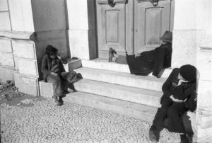 Lisbona. "Homeless" seduti sui gradini di un portone