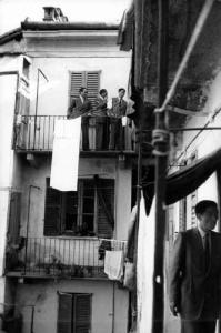 Italia Dopoguerra. Milano - Quartiere cinese - casa di ringhiera - alcuni uomini chiacchierano sul ballatoio