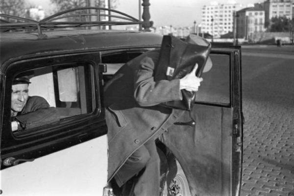 Barcellona - uomo scende da un'automobile nescondendo il volto con la borsa. Monarchico