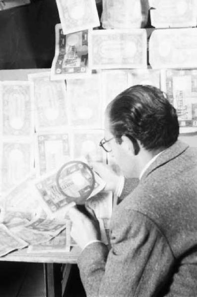Milano dopoguerra. Signore osserva con una lente una banconota da mille lire per verificarne l'autenticità.
