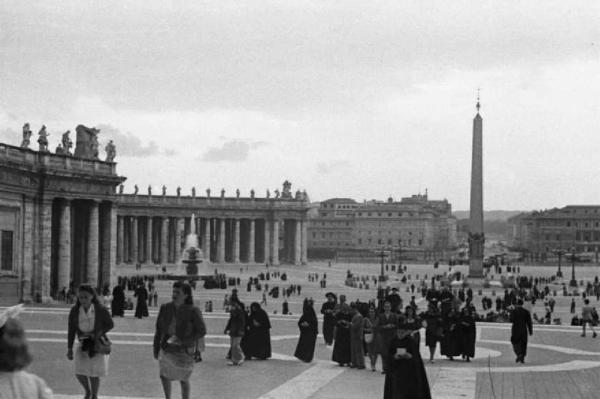 Roma - Basilica di S. Pietro. Veduta della piazza dal portico della basilica, con alcuni fedeli che si dirigono verso la chiesa