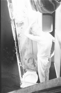 Milano - finestra aperta su un bagno. Uomo aziona lo sciacquone della tazza del gabinetto